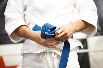 Image showing Person, karate and hands with belt, fight and sport for self defense with muay thai and training in gym. Athlete, combat and power with fitness, martial arts and warrior with exercise and taekwondo