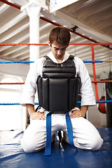 Image showing Karate, man and kneeling, exercise with fight in ring and martial arts, protection vest with prayer and ready for battle. Fitness, warrior and muay thai, training and challenge in gym for taekwondo