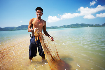 Image showing Fisherman, ocean and man with net working, nature and labor with fishing in Thailand and tropical island. Sea, job and rope with worker in water to catch fish and beach with environment and portrait