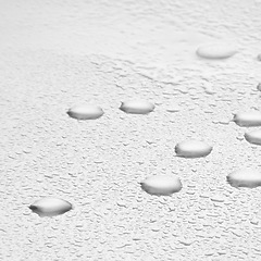 Image showing Water drops, texture and splash or white background with liquid, rain condensation or morning dew. Zoom, transparent and pure droplets, raindrops or bubbles of refreshing moisture on mock up space