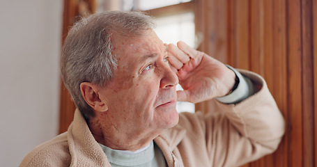 Image showing Depression, sad or nostalgia with a senior man looking through a window in his home during retirement. Thinking, memory or the past with an elderly person feeling lonely in the living room of a house