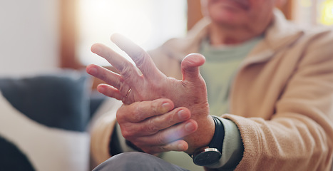 Image showing Closeup, hands and senior man with wrist pain, injury and inflammation with bruise, home and broken. Zoom, pensioner and elderly guy on a couch, fingers with ache and arthritis with sprain and strain