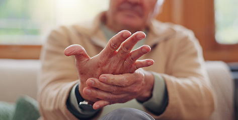 Image showing Closeup, hands and senior man with wrist pain, injury and inflammation with bruise, home and broken. Zoom, pensioner and elderly guy on a couch, fingers with ache and arthritis with sprain and strain