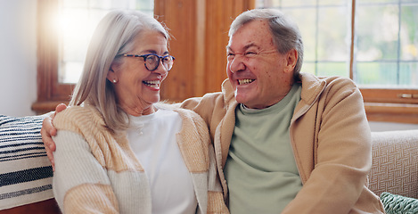 Image showing Senior couple, happiness and retired while laughing, talking and smile, couch and touch. Retirement, old age home and elderly in living room, couch and bonding together for quality time, hug or care