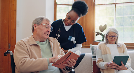 Image showing Senior man, reading and nurse talking in home with book, discussion or support from nursing staff. Retirement, elderly care or person relax in conversation with caregiver in living room with notebook