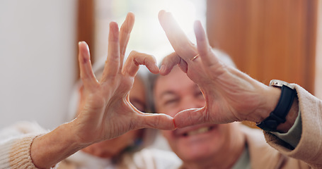 Image showing Mature couple, heart hands and love on home sofa for connection, marriage and bond. A happy man and woman together on a couch with emoji, shape or symbol for commitment, trust or health and wellness