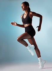 Image showing Fitness, health and black woman running in studio with blue background. Sports, exercise and form, motivation for strong runner cardio training for a marathon or race, workout for woman from Jamaica.