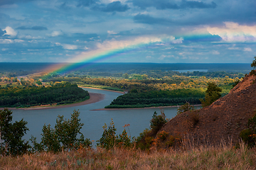 Image showing Rainbow with clouds over a river valley
