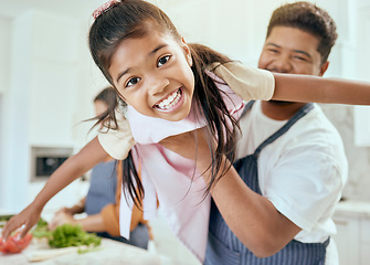 Image showing Family, kitchen and cooking together, smile in portrait and father lift child, learning and chef skill with parents and kid. Happy, food preparation and meal, man holding child and mother with veg.