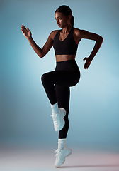 Image showing Runner, fitness and woman with energy while training, running and doing exercise against a blue mockup studio background. Gym, workout and athlete girl with a jump while doing cardio for body