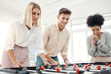 Image showing Business people, foosball table and competition in office for team building, motivation and teamwork in startup company. Group diversity employees playing creative soccer games for fun collaboration