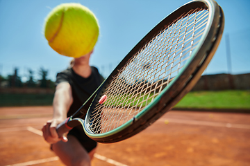 Image showing Close up photo of a young girl showing professional tennis skills in a competitive match on a sunny day, surrounded by the modern aesthetics of a tennis court.