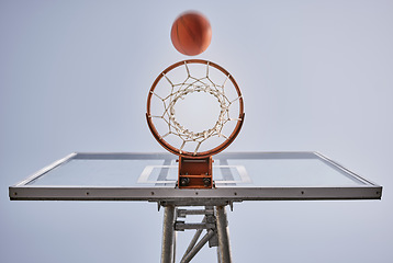 Image showing Basketball, shooting ball and target of outdoor sports goals, competition game and action on sky background. Background basketball court, air net and winning contest, training skill and performance