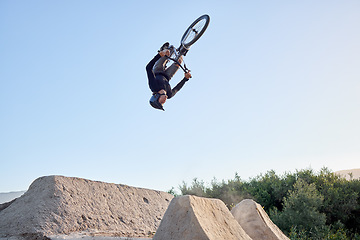 Image showing Mountain, bike and cyclist man riding bicycle for a dangerous risk stunt. Fitness, adrenaline junkie and extreme sports with a healthy biker jumping for a trick on his bike for adventure and fun