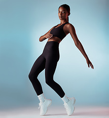 Image showing Fitness, health and body black woman in studio portrait dancing for performance, workout and training marketing mock up. Sneakers, shoes or fashion model dancer balance on legs for an exercise dance