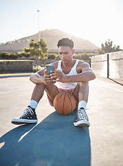 Image showing Phone, fitness and basketball man relax typing training results on mobile app, gaming or reading blog update. Basketball player teen on ground and 5g smartphone using phone for social media