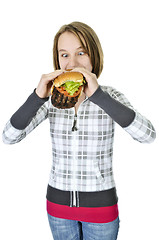 Image showing Teenage girl eating big hamburger