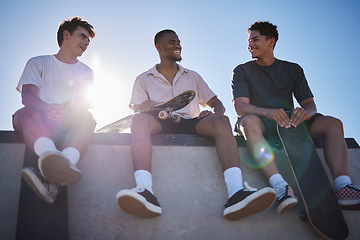 Image showing Diversity, friends and men with skateboard together talking on wall in city. Happy conversation, laughing and gen z skater friendship group with street fashion bonding at skate park outdoors