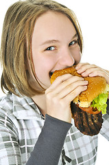 Image showing Teenage girl holding big hamburger