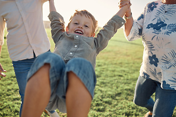 Image showing Happy, grass and child holding hands with parents on nature walk in a field on a summer holiday. Family, support and love, happiness in fun quality time with young boy walking and playing on vacation
