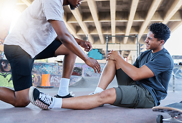 Image showing Sports injury, knee and skater man holding wound after accident, falling and fail on skateboard at urban community skate park. Male friends, skating and helping with sore leg during training