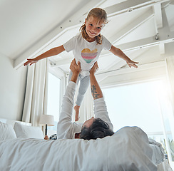 Image showing Playful, bedroom and father holding his child while relaxing on the bed together in their home. Happy, smile and portrait of girl kid playing, resting and bonding with her dad in the room of a house.