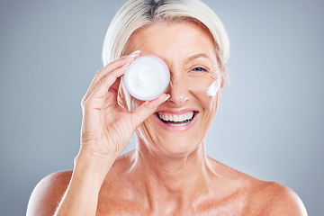 Image showing Beauty, skincare and senior woman with face cream for moisturizing on a gray studio background. Smile, model and female with facial creme, lotion or cosmetics product for healthy skin or anti aging.