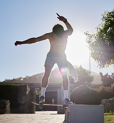 Image showing Skateboard, ramp and young man doing a trick at an outdoor park for fun, fitness or training. Adventure, freedom and athlete or skater doing a extreme sports stunt in nature in a urban street.