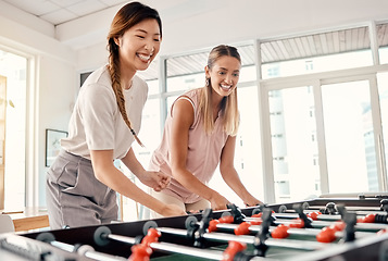 Image showing Foosball, women and friends playing table soccer in an office for fun, bonding and competition at work with happiness, energy and motivation. Employees enjoying football game for team building