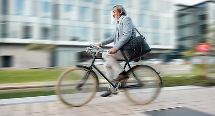 Image showing Bike, commute and blurred motion with a mature man in business cycling in the city on his morning trip into work. Road, travel and bicycle with a senior male employee riding on a street in town