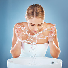 Image showing Woman, water or washing face in grooming skincare on blue background studio from sink or basin. Beauty model, wet and facial cleaning with water splash for hygiene maintenance, healthcare or wellness