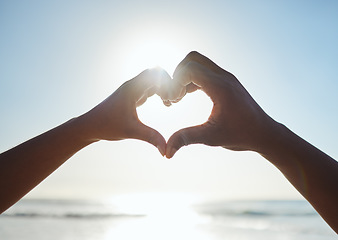 Image showing Heart, love and couple hands on beach with blue sky for summer, outdoor health and holiday for nature, earth day and travel. People with care sign together for ocean, sea and clean water with mock up