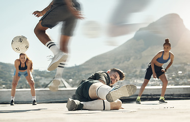 Image showing Soccer, sports and tackle with a man player sliding an opponent during a game or match on a city rooftop outdoor. Football, fitness and exercise with a soccer player slide tacking for competition