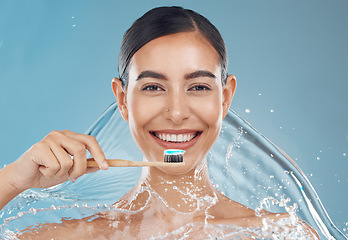 Image showing Woman brushing teeth, water splash and toothbrush, toothpaste and dental cleaning of mouth wellness on blue background in studio shower Portrait face of healthy teeth, big smile or facial beauty care