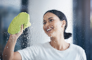 Image showing Cleaning, washing window and woman with cloth in hand to wipe water, detergent and cleaning products. Hygiene, housekeeping and happy girl doing housework, chores and and wash or clean clear glass