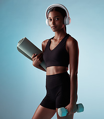 Image showing Headphones, fitness and exercise woman in studio with dumbbells and yoga or cardio gear for workout wellness, exercise or training fashion portrait. Black woman with sports music and health mock up