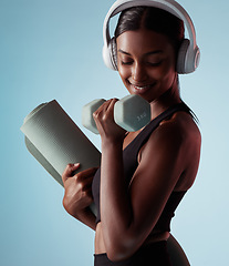 Image showing Yoga, dumbbell and woman in studio training strong biceps in exercise with headphones for music streaming. Fitness, healthy and happy girl listening to audio, radio and lifting weights for arm power
