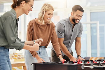 Image showing Business people play foosball table in office for team building competition, staff motivation or happiness in startup. Employees enjoy creative football games for happy teamwork challenge in company