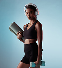 Image showing Yoga, music and woman with a dumbbell for fitness training and mat in pilates workout exercise in a studio. Sports, wellness and healthy girl streaming or listening to radio or podcast in headphones