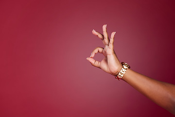 Image showing Hand, woman and okay sign at a studio in support of decision, approve and yes closeup on red background mockup. Model hands and ok gesture by girl showing signal for approval, agree and continue