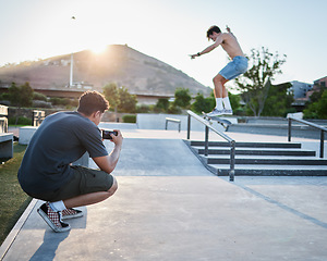 Image showing Skateboard jump outdoor, photographer in park for extreme sports photoshoot with skater in summer. Skatepark photo session, man grind rail and sport for fitness, stunt and training in Cape Town