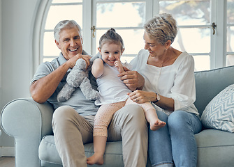 Image showing Family, grandmother and grandfather with girl on sofa, having fun and bonding. Portrait, love and care of happy grandparents with kid or child on couch in living room enjoying quality time together.