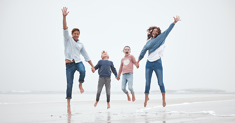 Image showing Beach, jump and portrait of parents with children having fun on family holiday, vacation and weekend getaway. Happiness in mom, dad and kids jumping by the ocean enjoying nature, outdoors and the sea