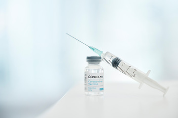 Image showing Covid, vaccine and syringe with bottle for safety, health and protection from virus in hospital with mockup space. Zoom of container, medicine and pharmaceutical product for covid 19 for healthcare