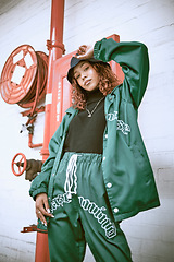 Image showing Fashion, wall and black woman with green clothes, fashionable style or cool hip hop outfit. Fire hose, attitude or portrait of gen z girl with trendy streetwear, designer brand or 2000s rap aesthetic