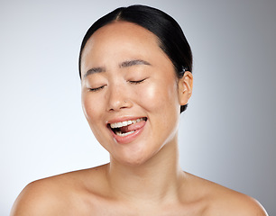 Image showing Woman face, tongue out and beauty skincare natural makeup glow. Young happy Asian girl, funny face eyes closed and healthy facial or body cosmetics for advertisement in grey studio background