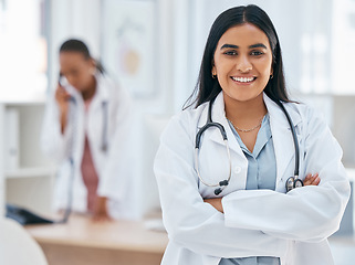 Image showing Indian woman, doctor and arms crossed in hospital with trust, wellness goals or healthcare motivation. Portrait, smile or happy medical worker, life insurance employee or friendly consulting surgeon