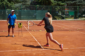 Image showing A professional tennis player and her coach training on a sunny day at the tennis court. Training and preparation of a professional tennis player