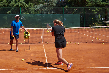 Image showing A professional tennis player and her coach training on a sunny day at the tennis court. Training and preparation of a professional tennis player