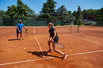 Image showing A professional tennis player and her coach training on a sunny day at the tennis court. Training and preparation of a professional tennis player